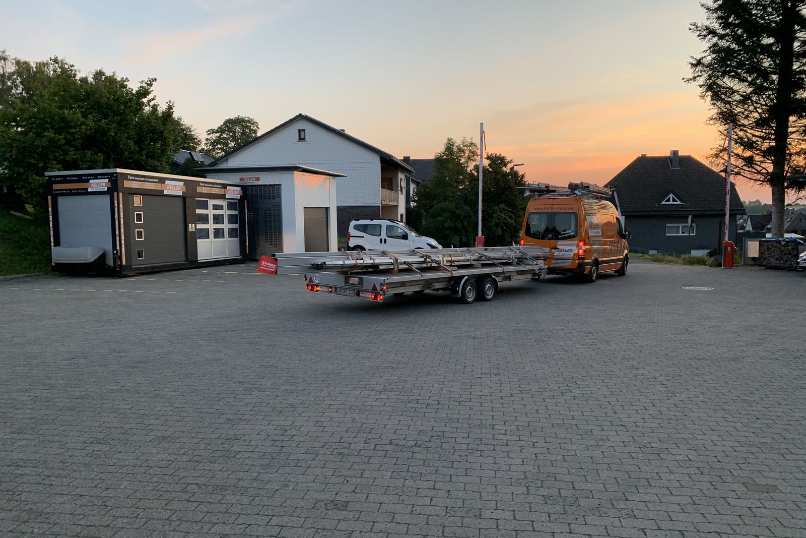 Betriebsgelände von Keller Tor-Systeme am Abend mit Transportanhänger
